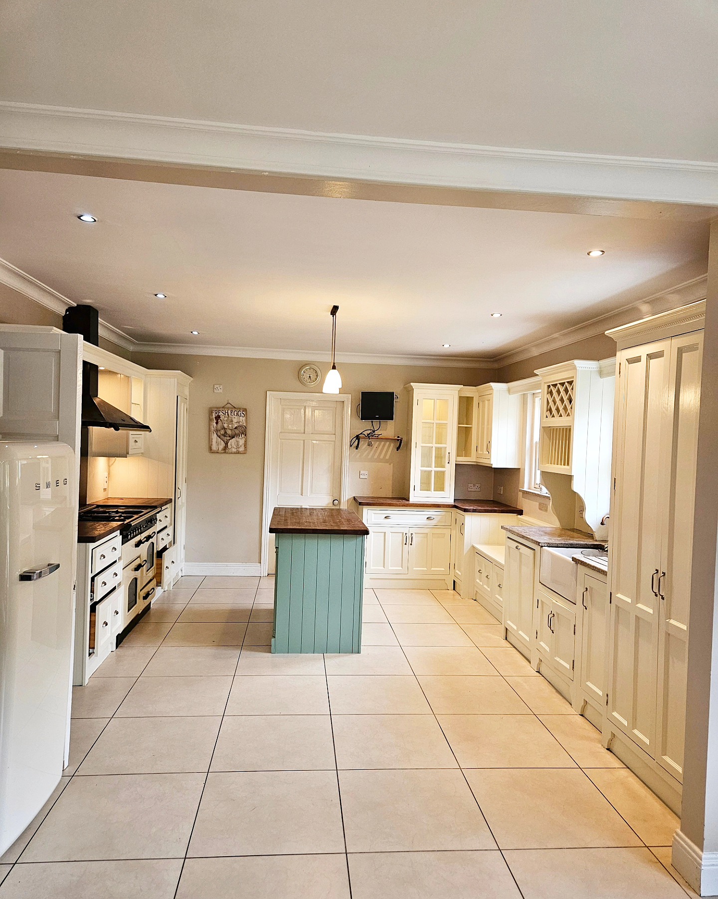 Hand painted cream kitchen cabinets with turquoise island in Limerick home